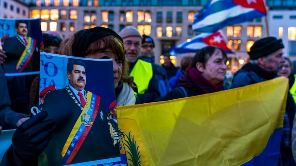 Purtret da protestas a Venezuela. Ina dunna tegna enta maun in purtret da Maduro. 