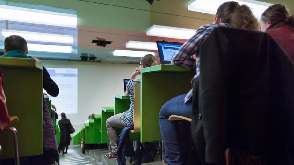 persunas sesan sin bancs en ina sala da prelecziun 