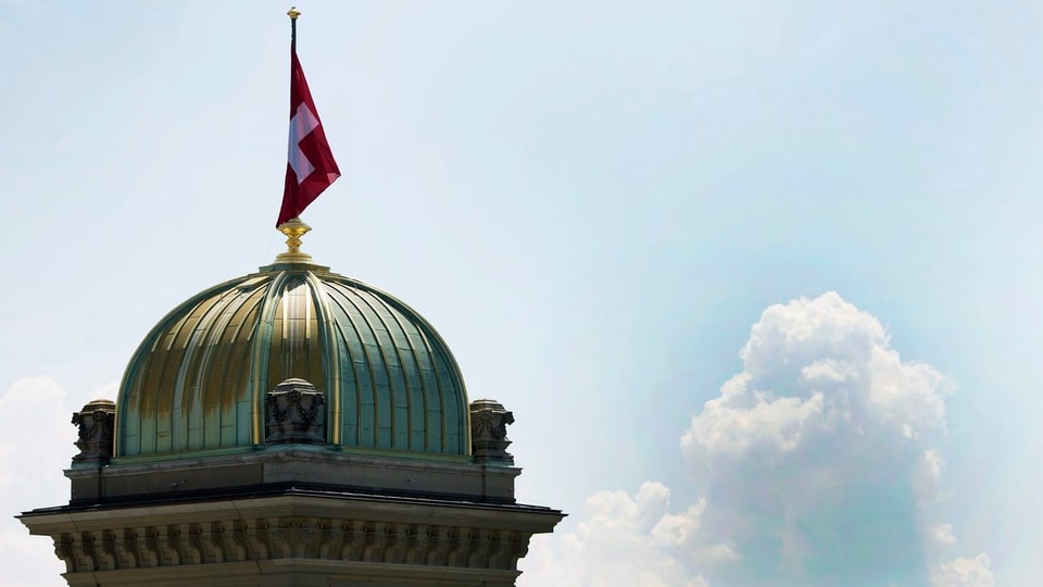 Purtret dal tetg dal parlament svizzer cun si la bandiera svizra. 