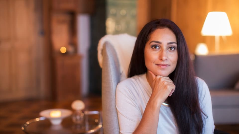 Auf dem Bild ist die Psychotherapeutin Sereina Venzin sitzend auf einem Stuhl zu sehen. Sie lächelt leicht.