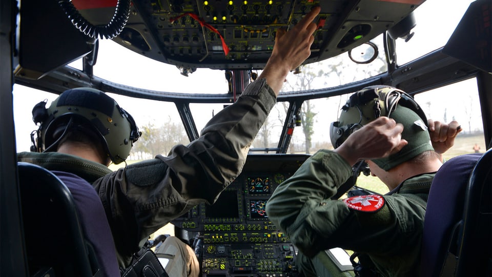 Dus pilots da l'armada svizra en il helicopter. 