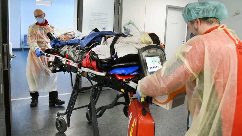 Duas persunas da tgira transportan in pazient sin ina purtantina en l'ospital.in 