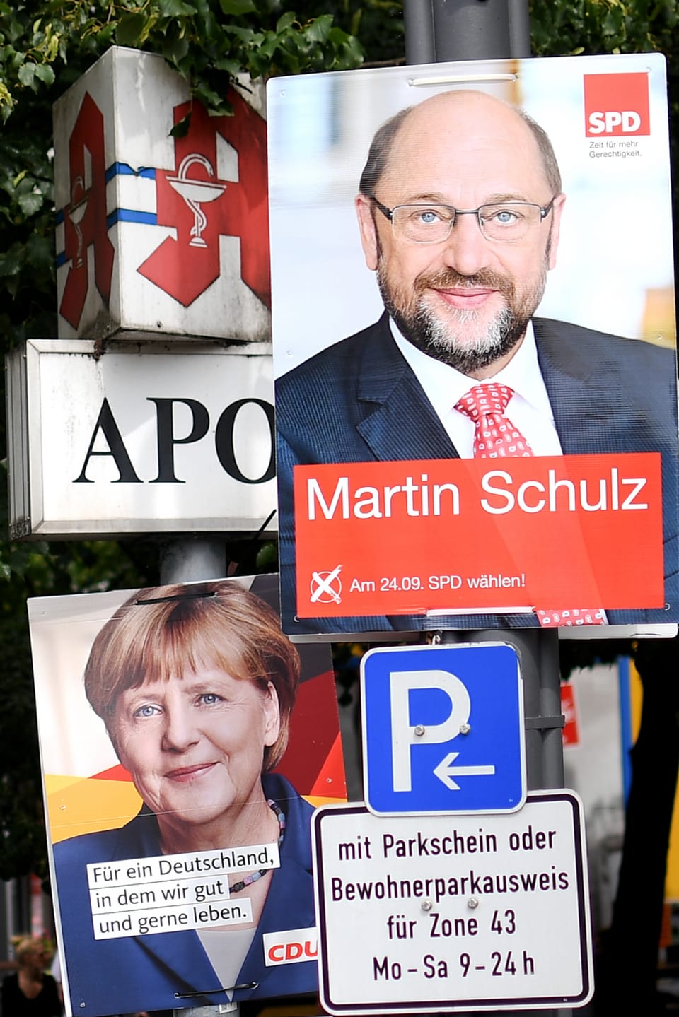 Placats dad Angela Merkel e Martin Schulz vid in pitga cun tavla da parcar ed inscripziuns.