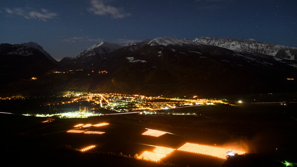 Ina vista sin tut la val la notg cun las chandailas che illumineschan las vignas.
