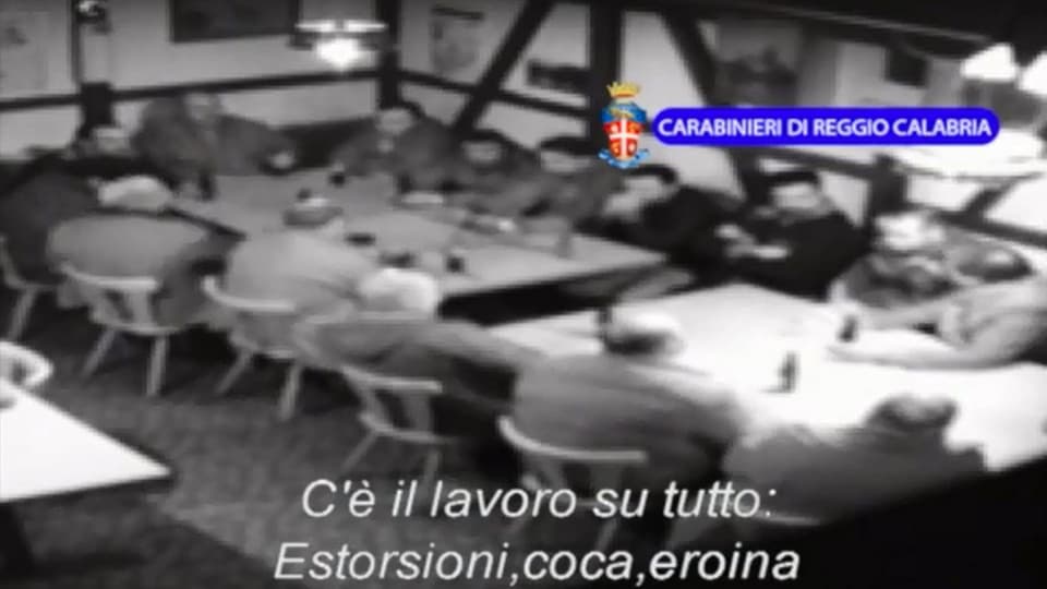 Ina dunzaina dad umens sesa enturn ina maisa en in restaurant svizer.