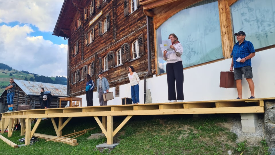 Die Schauspielerinnen und Schauspieler stehen für die erste Probe auf der Bühne vor dem Haus Fausta Capaul in Brigels. 