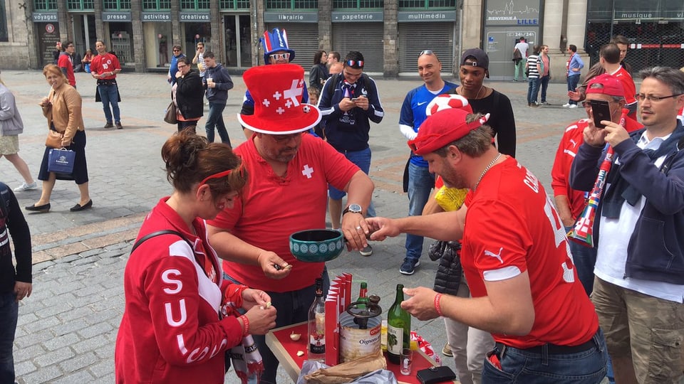 Fans svizzers preparan in Fondue amez ina plazza a Lille