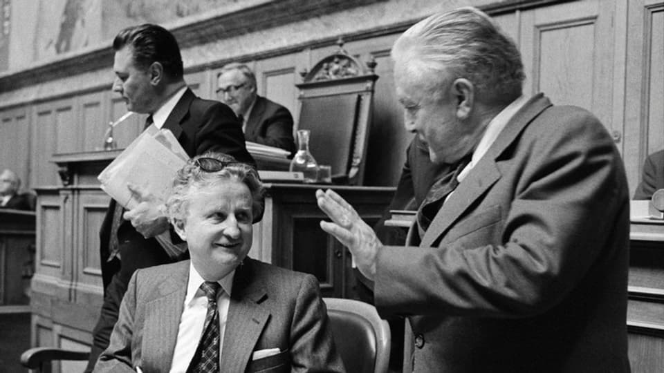L'anteriur cusseglier naziunal Paul Eisenring (san.) en discurs cun cusseglier federal Georges-Andre Chevallaz (dre.).