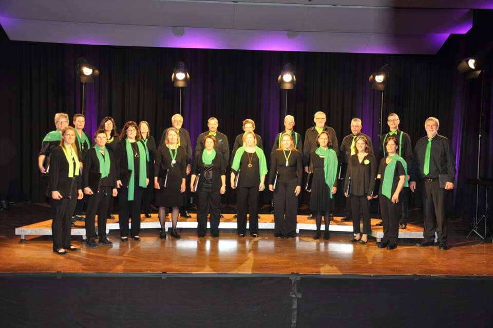 Gemischter Chor, Chor Uvriu Danis-Tavanasa, gekleidet in schwarz mit grünen Accessoires