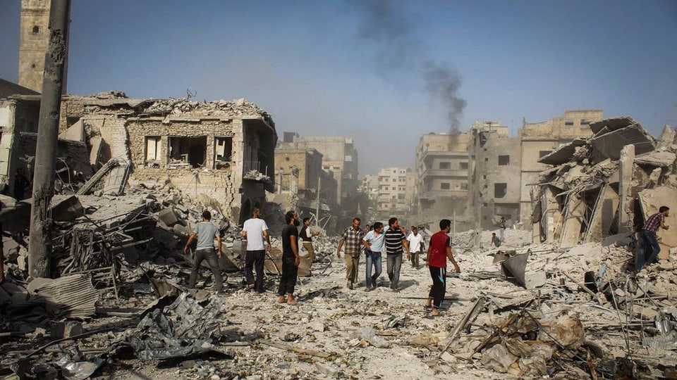 Siria, ruinas da chasas suenter in'attatga, pliras persunas van tras las ruinas