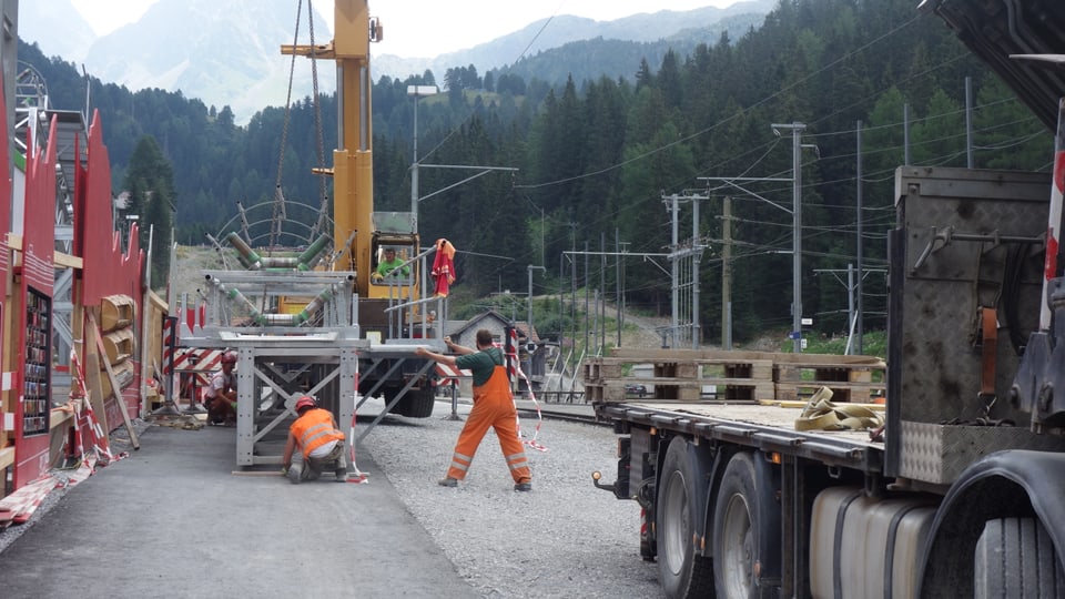 Camiuns portan la tschinta da transport (Förderband), che vegn duvrà per il transport da la crappa dal tunnel.