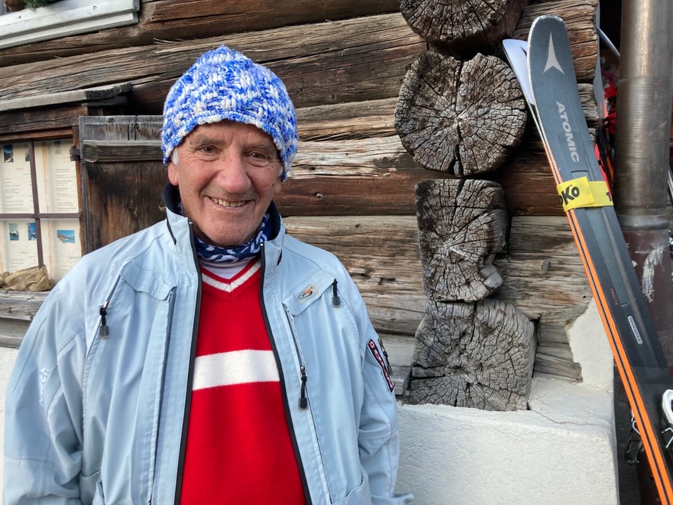 mann mit blau weisser mütze, rotem pullover und hellblauer jacke