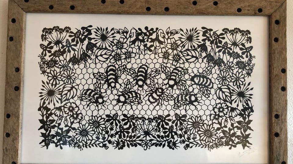 Avieuls e flurs, era quai ina creaziun da «la zambergiera» Bienen und Blumen im Scherenschnittkunstwerk.