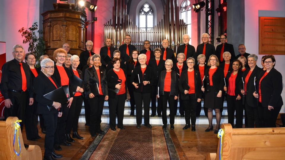 Der gemischte Chor Las Vuschs dil Rein ganz in schwarz und mit roten Blusen oder die Männer mit roten Krawatten.
