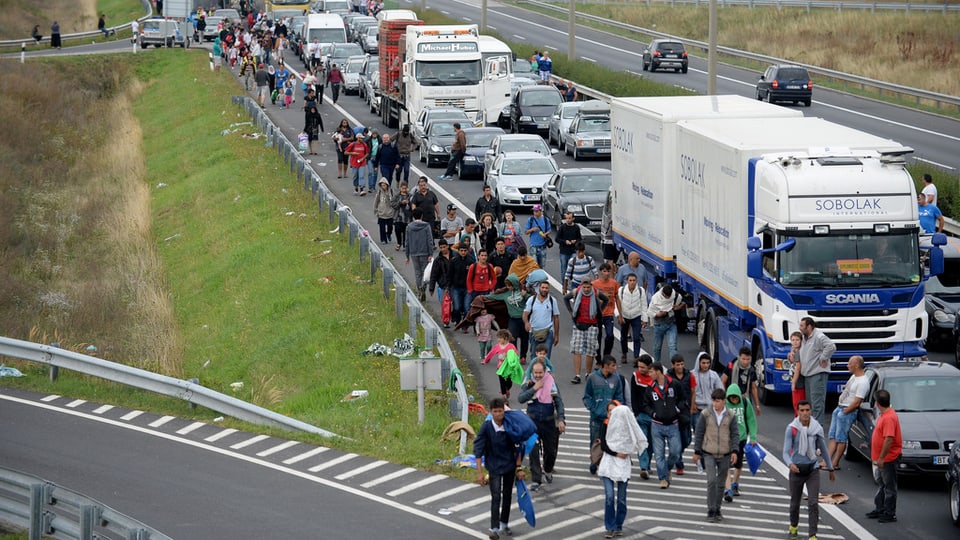 Fugitivs van a pe sin l’autostrada per vegnir da l’Ungaria en l’Austria.