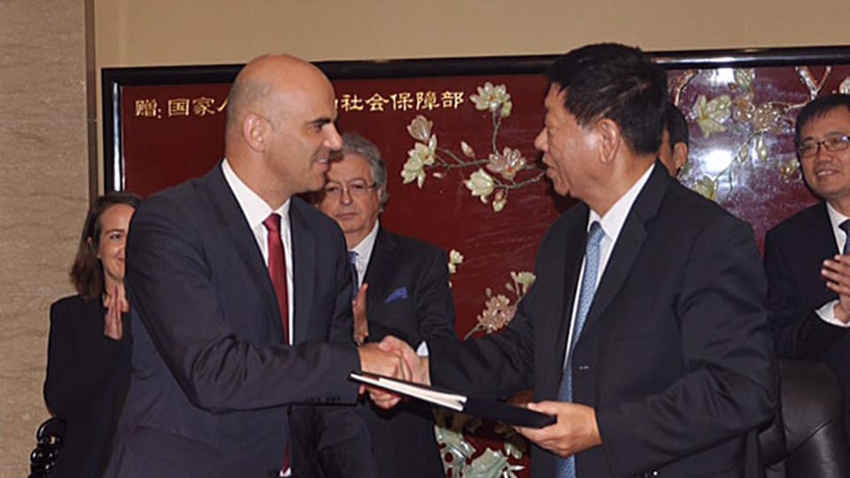Cusseglier federal Alain Berset ed il minister dal socialesser Yin Weimin suenter avair suttascrit la cunvegna.