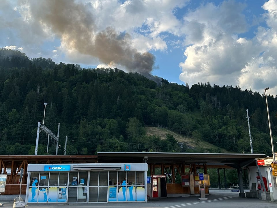 Rauch steigt aus dem Wald über Ilanz vor dem Kiosk