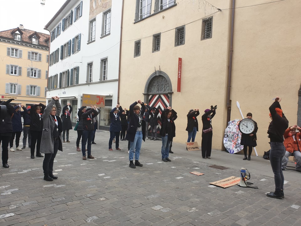 Las var 30 demonstrantas e demonstrants tegnan lur mauns ad ault.