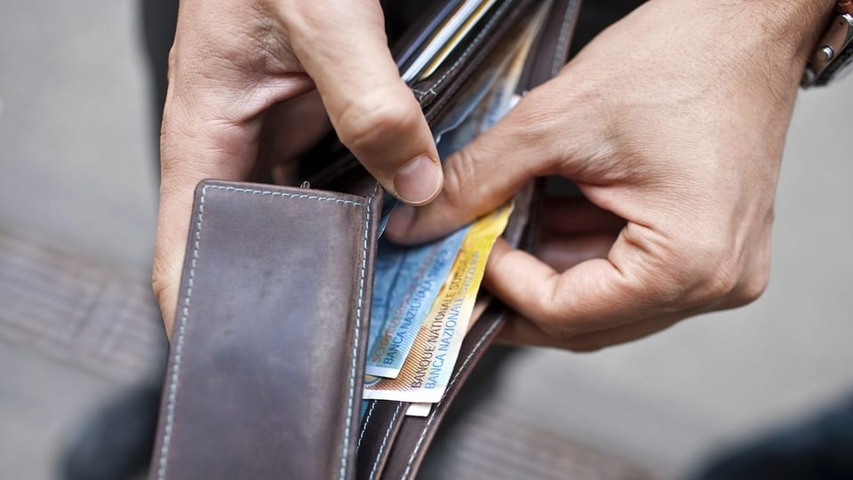 Mauns che avran ina bursa cun en pliras bancnotas.