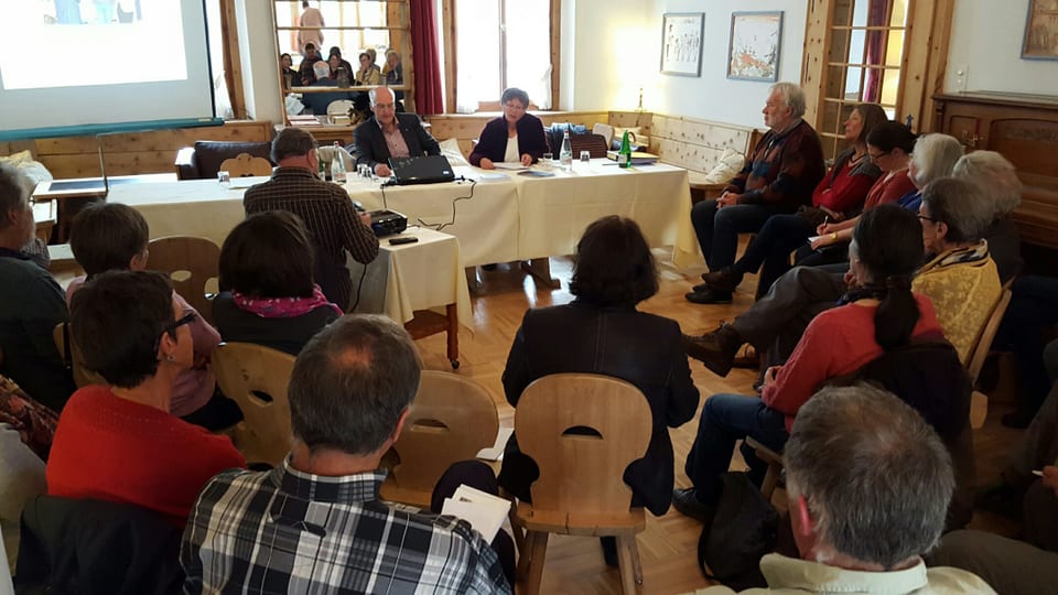 Participants da la radunanza generala da l'UDG a Zuoz sesan en rudè e discutan