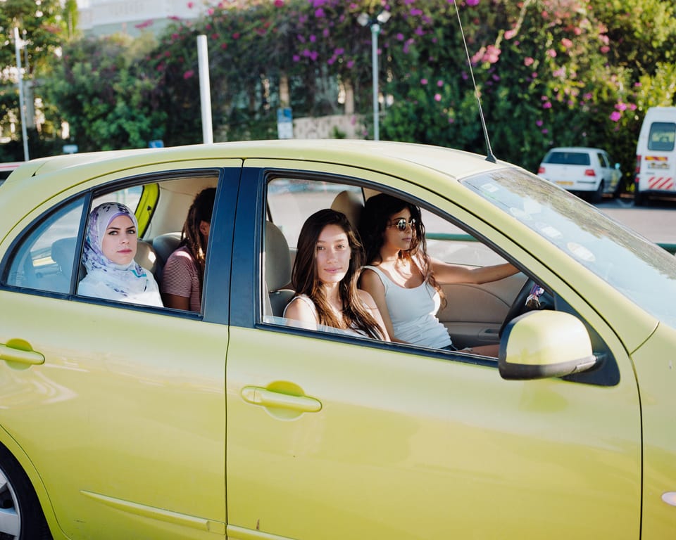 4 junge Frauen in einem grünen Auto.