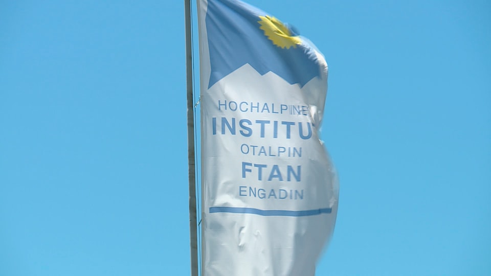 Bindera cun logo da l'Institut Otalpin a Ftan