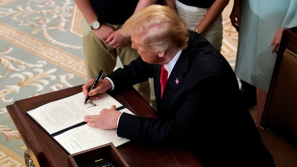 Purtret da Trump co el suttascriva in document. 