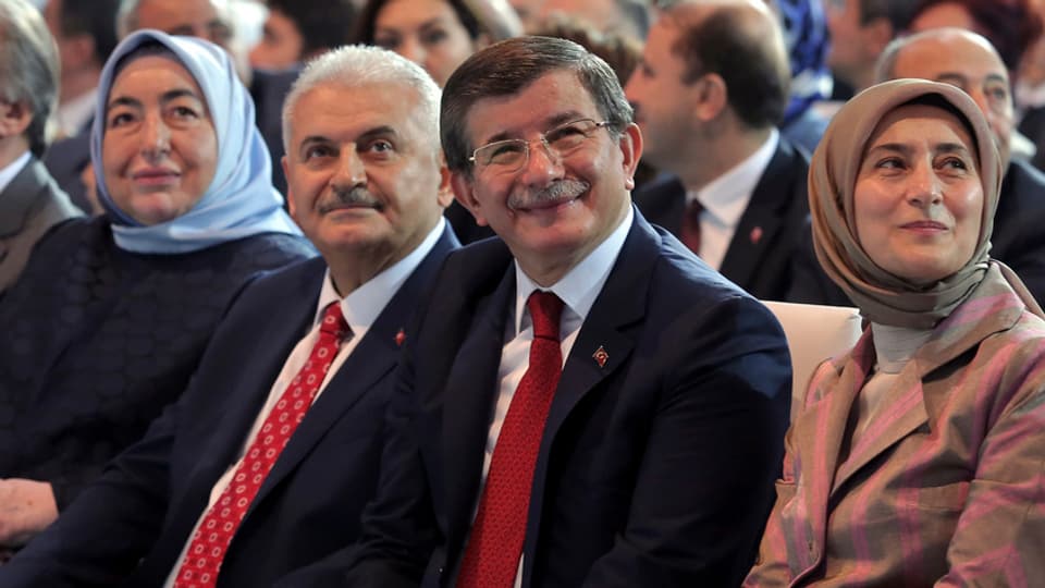 Il nov ed il vegl - Yildirim e ses antecessur Davutoglu flancads da lur dunnas.