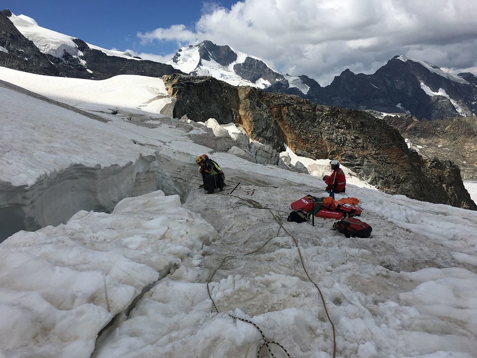 Alpinists salvaders e la crew da la Rega al lieu da salvament.