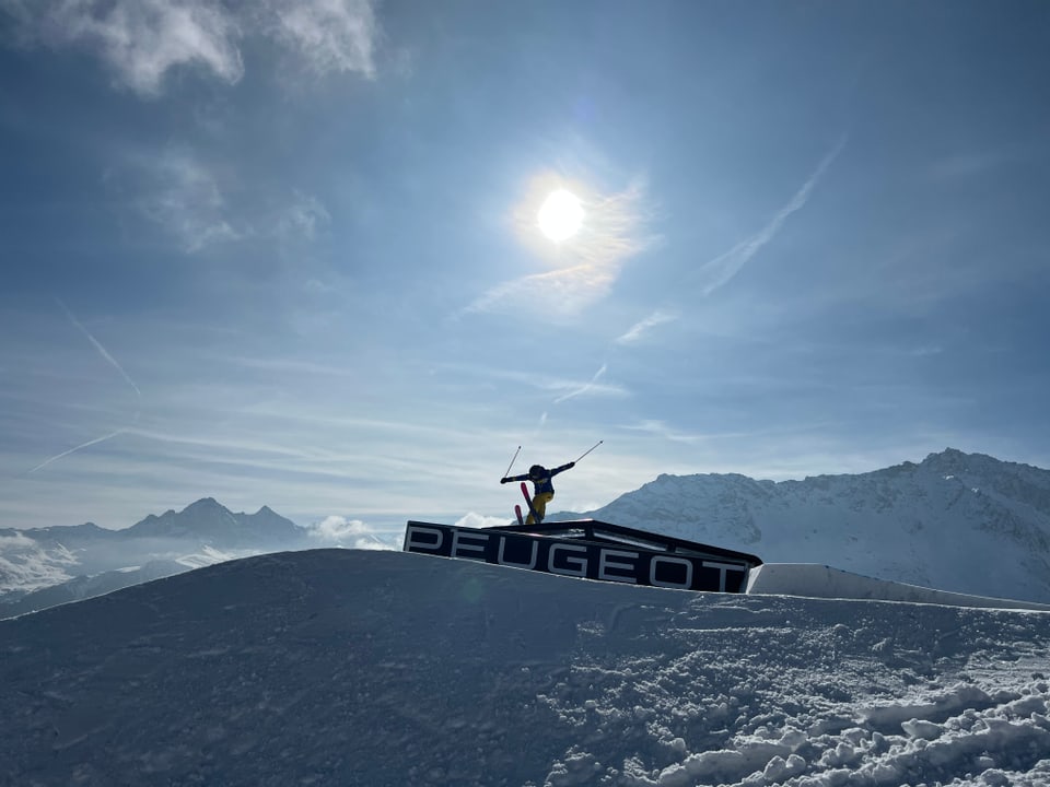 Skifahrer fährt über eine Rail.