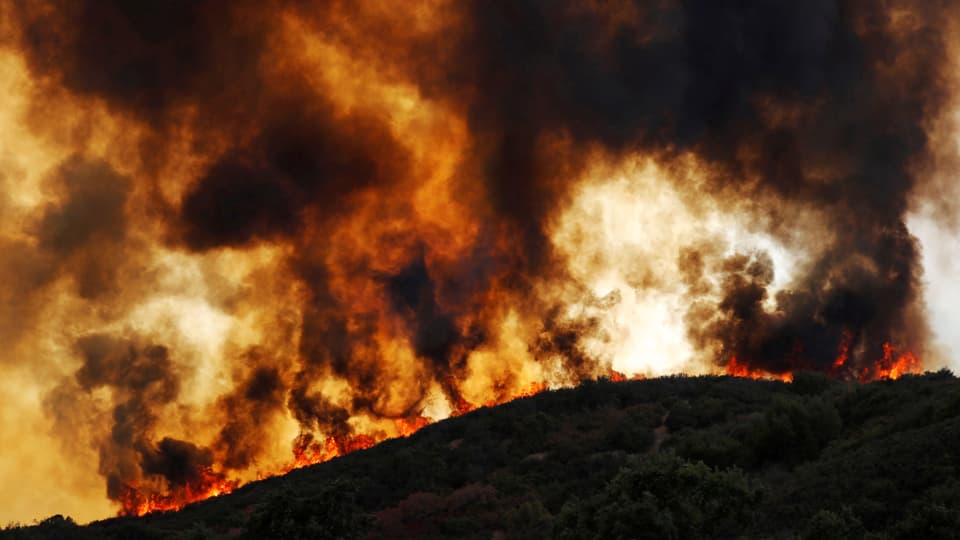 Purtret da l'incendi grond. Colurs intensivas, oransch dal fieu ed ils nivels da fim nairs. 