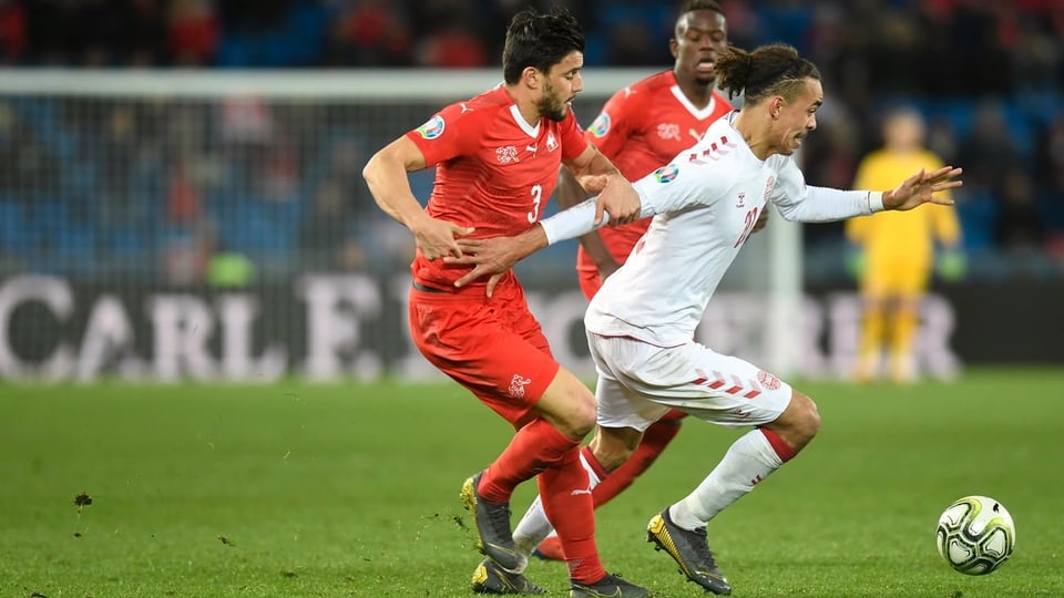 Loris Benito (Svizra) cunter Yussuf Poulsen (Danemarc) durant il gieu da qualificaziun tranter Svizra e Danemarc en il stadion St. Jakob-Parc a Basilea. 