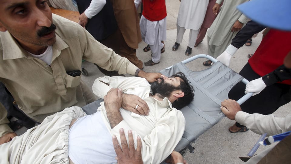 Forzas da salvament transporteschan in um blessà a Peshawar en il Pakistan.