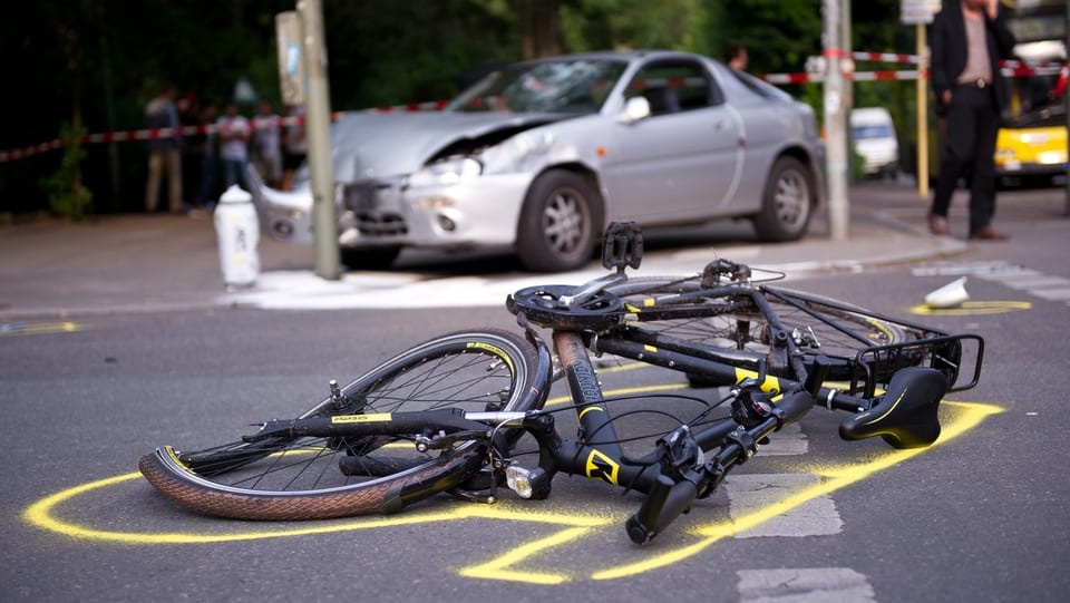 Accident tranter in velo ed in auto. Il velo e rut per terra e l'auto ha in donn ed è pli davostiers.